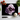 Black chopping board with a large purple rose print, surrounded by cherry tomatoes, garlic, basil, and a kitchen knife