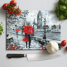London-themed chopping board with red umbrellas art, fresh tomatoes, basil, garlic, and chef knife on white surface