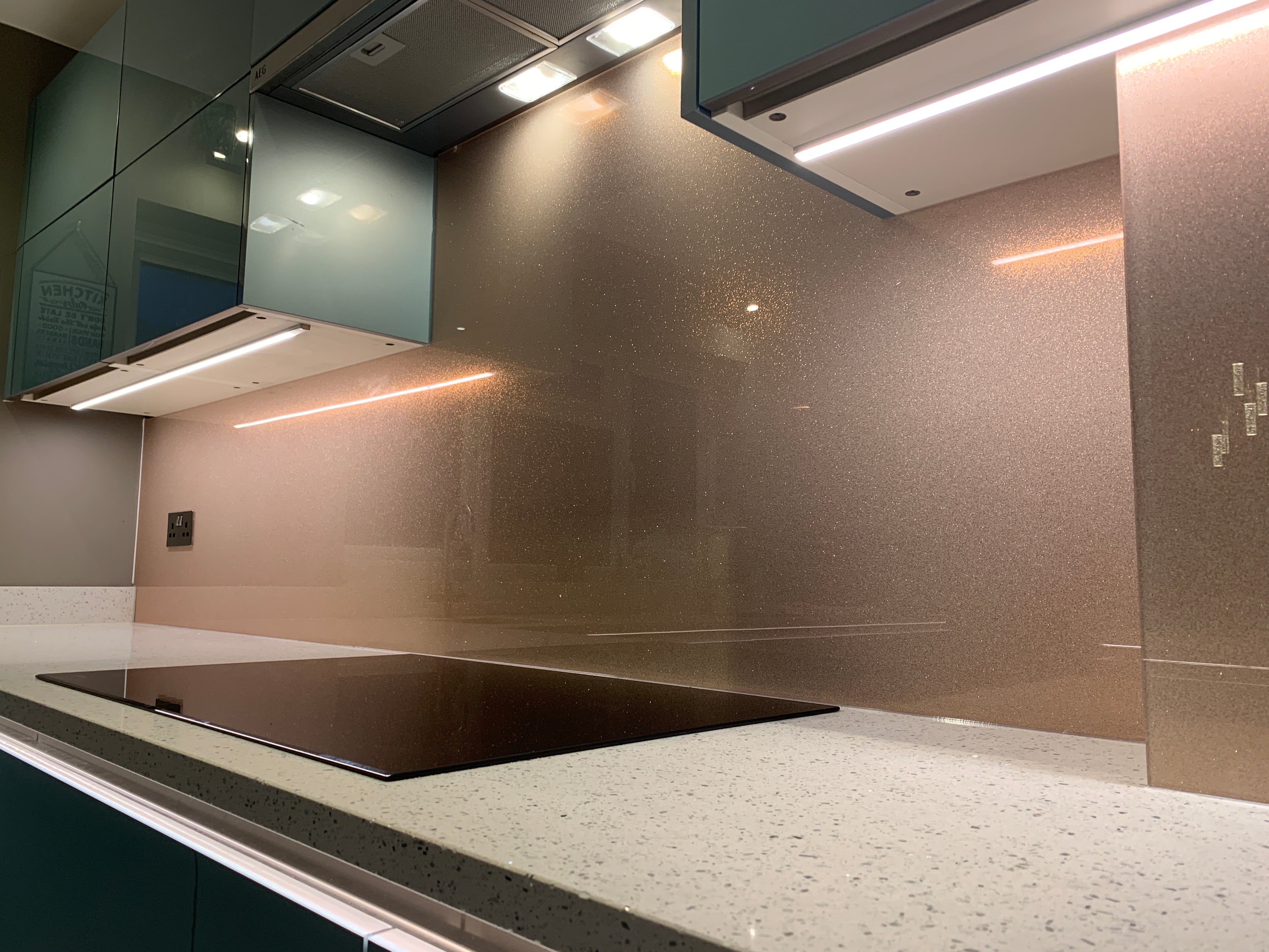 Rose gold fine glitter kitchen glass splashback made and installed by CreoGlass in London UK