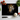 Kitchen scene with black chopping board featuring a tiger face, surrounded by tomatoes, garlic, basil, and a knife