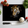 Kitchen scene with black chopping board featuring a tiger face, surrounded by tomatoes, garlic, basil, and a knife