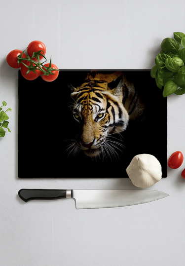 Kitchen scene with black chopping board featuring a tiger face, surrounded by tomatoes, garlic, basil, and a knife