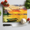 Chopping board with sunset seascape featuring small boat, tomatoes, basil, garlic, and kitchen knife