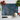 Textured blue chopping board with a chef knife, garlic bulb, fresh tomatoes and basil leaves on white surface