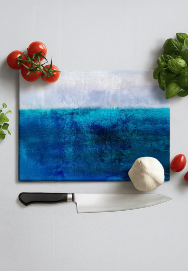 Rectangular chopping board with textured blue shades design surrounded by kitchen knife, garlic, tomatoes, and basil leaves