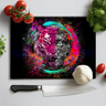 Vibrant chopping board with colorful tiger and mechanical gears design, surrounded by tomatoes, garlic, basil, and kitchen knife