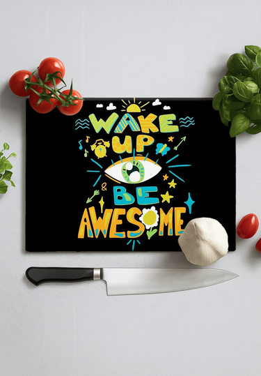Black chopping board with colorful text 'Wake Up Be Awesome' surrounded by tomatoes, garlic, basil, and a kitchen knife