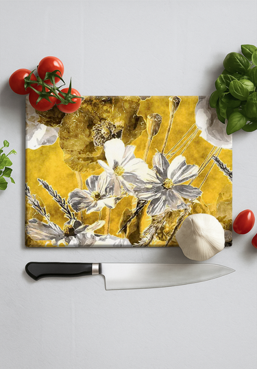 Floral decorative cutting board with tomatoes, basil, garlic, and chef knife on white surface
