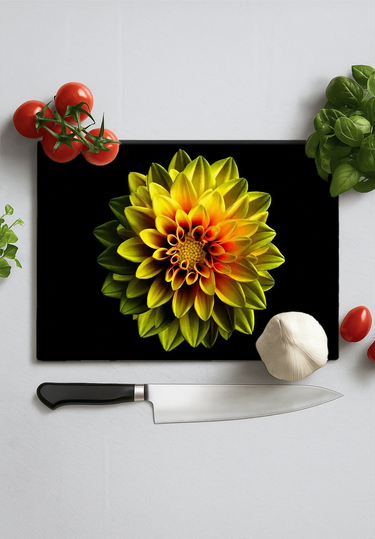 Black chopping board with vibrant yellow and red dahlia print surrounded by cherry tomatoes, garlic, basil, and chef knife