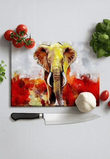 Colorful elephant design chopping board with knife, tomatoes, garlic, and basil on white surface