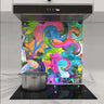 Vibrant abstract art glass splashback in modern kitchen with induction hob and stainless steel pot