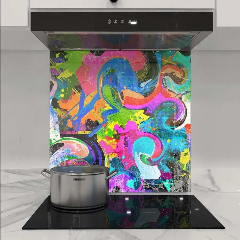 Vibrant abstract art glass splashback in modern kitchen with induction hob and stainless steel pot