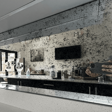 Bespoke speckled glass backsplash in modern kitchen with sleek black cabinets and LED lighting