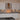 Modern kitchen with sleek white cabinets, black granite countertops, and glass backsplash with LED lighting