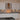 Modern kitchen with sleek white cabinets, black granite countertops, and glass backsplash with LED lighting