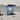 Blue abstract glass splashback in modern kitchen with white cabinets and marble countertop