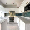 Modern kitchen with bespoke decorative glass splashback in teal marble effect, white cabinetry and LED lighting