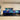 Vibrant blue and gold abstract glass splashback in modern kitchen with white cabinets and black countertop