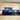 Bespoke blue and gold abstract glass splashback in modern white kitchen with black countertop