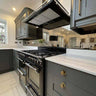 Luxury kitchen with grey cabinets, black range cooker, and decorative glass splashback
