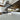 Modern kitchen with sleek glass backsplash, marble countertop, and stainless steel range hood