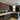 Modern kitchen with sleek dark cabinets, marble countertop, and feature mirror backsplash