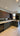 Modern kitchen with sleek dark cabinets, marble countertop, and feature mirror backsplash