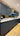 Modern kitchen with sleek dark cabinets, white countertop, and glass backsplash