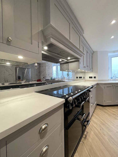 Luxury kitchen with bespoke feature mirror backsplash, sleek cabinets, and modern appliances