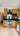 Modern kitchen with wooden cabinets, black countertop, and glass backsplash reflecting light