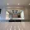 Bespoke feature mirror above kitchen island, reflecting luxury residential interior with recessed lighting