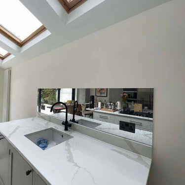 Bespoke feature mirror above marble kitchen sink with skylights, modern luxury residential design