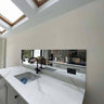 Bespoke feature mirror above marble kitchen sink with skylights, modern luxury residential design