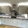 Modern kitchen with sleek white cabinets, marble backsplash, and reflective glass feature wall