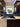 Vibrant underwater scene glass splashback in modern kitchen with dark cabinets and sink