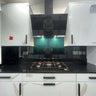 Modern kitchen with black glass backsplash and LED-lit feature panel above gas hob