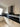 Modern kitchen with black glass splashback and white cabinets, featuring sleek design and contemporary style.