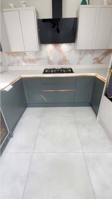Modern kitchen with marble-effect glass splashback and sleek grey cabinets