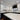 Modern kitchen with white cabinets, marble backsplash, and LED-lit countertops