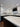 Modern kitchen with white cabinets, marble backsplash, and LED-lit countertops