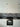Marble-effect glass splashback in modern white kitchen with built-in oven and black countertop