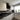 Modern kitchen with black marble-effect glass splashback and matching floor tiles, featuring sleek white cabinets and LED lighting.