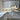 Modern kitchen with white cabinets, marble-effect glass splashback, and copper handles