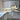 Modern kitchen with white cabinets, marble-effect glass splashback, and copper handles