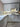 Modern kitchen with white cabinets, marble-effect glass splashback, and copper handles