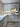 Modern kitchen with white cabinets, marble-effect glass splashback, and copper handles
