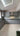 Modern kitchen with grey cabinets, marble-effect glass backsplash, and skylight