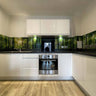 Modern kitchen with forest-print glass splashback, white cabinets, and wood flooring