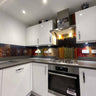 Modern kitchen with colorful decorative glass splashback behind stainless steel hob and oven
