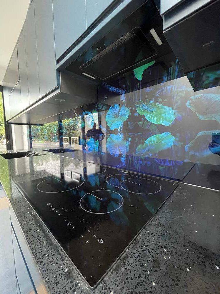 LED backlit glass kitchen splashback with vibrant leaf patterns, modern luxury interior design